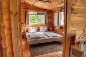 a bedroom with a bed in a log cabin at Ferienhaus Ankerplatz Bellin in Ueckermünde