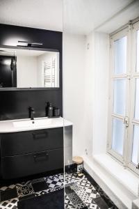 a bathroom with a sink and a mirror at Le Passage - Centre-ville - WiFi in Issoire +20 photos