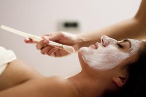 a woman brushing her teeth with a plastic mask on her face at Camping Terme Catez - Maeva Vacansoleil in Brežice