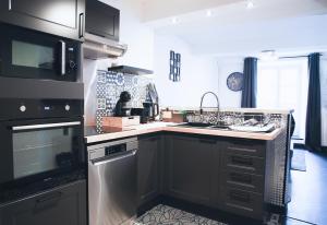 a kitchen with a sink and a stove at Le Passage - Centre-ville - WiFi in Issoire