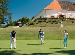 three people playing golf on a golf course at Camping Terme Catez - Maeva Vacansoleil in Brežice