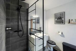 a bathroom with a shower with a toilet and a sink at Le Duplex appartement proche de la Cathédrale in Bayeux