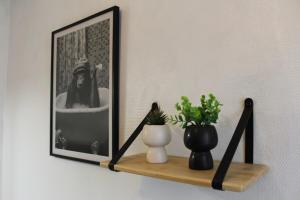 a shelf with a picture and a vase on it at Le Duplex appartement proche de la Cathédrale in Bayeux +10 photos