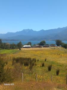 a field with a fence and a building in the distance at Cabaña Terraza del Yates in Puerto del Yate