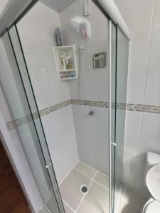 a shower with a glass door in a bathroom at Quarto em Apartamento na Trindade in Florianópolis +3 photos
