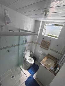 a small bathroom with a toilet and a window at Quarto em Apartamento na Trindade in Florianópolis