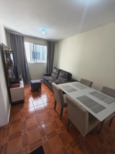 a living room with a table and a couch at Quarto em Apartamento na Trindade in Florianópolis
