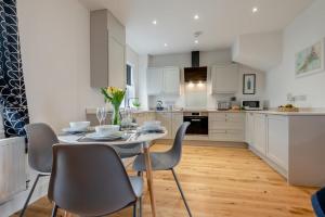 a kitchen with white cabinets and a table and chairs at 2 Bed in Bude oc-u31759 in Bude +20 photos