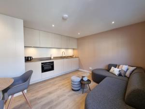 a living room with a couch and a kitchen at LÖYLY Egmond in Egmond aan Zee