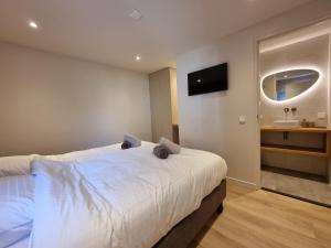 a bedroom with a bed with a sink and a mirror at LÖYLY Egmond in Egmond aan Zee +18 photos