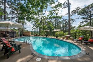 a large swimming pool with chairs and umbrellas at The Woodsman Lodge in Eureka Springs