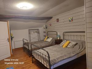 zwei Einzelbetten in einem Schlafzimmer mit einer Wand in der Unterkunft La Tignoise in Tignac