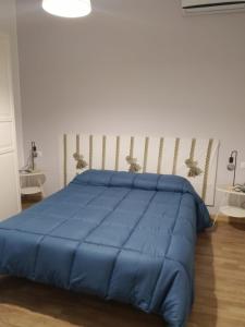 a blue bed in a bedroom with two tables at La Casa delle Onde B&B in Pescara