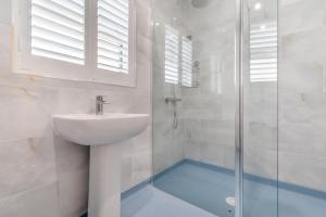 a white bathroom with a sink and a shower at 3 Bed in Tenby oc-m29588 in Tenby +17 photos