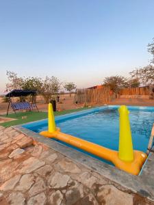 a swimming pool with yellow inflatable cones around it at Petrified forest restcamp in Khorixas