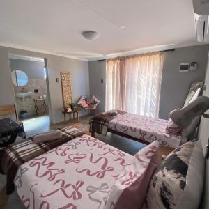 a room with two beds and a couch in it at Petrified forest restcamp in Khorixas