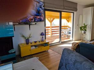 a living room with a tv and a yellow table at Apartamenty Dzika Orlica in Zieleniec