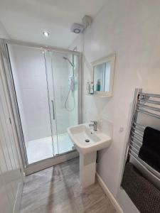 a white bathroom with a shower and a sink at 4b Smart Apartments in Newark-on-Trent