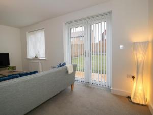 a living room with a couch and a large window at 10 The Colliery in Telford