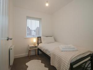 a small bedroom with two beds and a window at 10 The Colliery in Telford