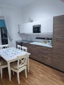 a kitchen with a table and chairs and a kitchen with white cabinets at La Casa delle Onde B&B in Pescara