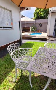 a white wrought iron table and chair in a yard at Bungalows Ailen in Federación