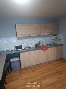 a kitchen with wooden cabinets and a microwave at Noclegi Spoko in Mąchocice