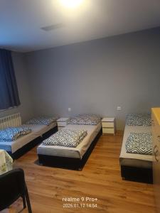 three beds in a room with wooden floors at Noclegi Spoko in Mąchocice