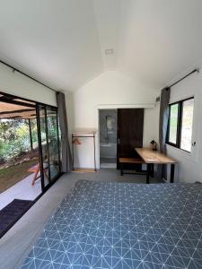 a room with a bed and a desk and windows at Spiral Resort in Ko Phayam