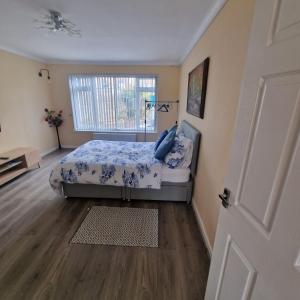 a bedroom with a bed and a window at Clover Crest - 3-Bedroom House in Bourton on the Water