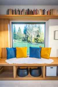 a window seat with yellow and blue pillows at Jiná báseň in Pustá Rybná