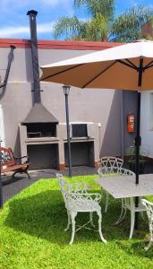 a table and chairs under an umbrella with a grill at Bungalows Ailen in Federación