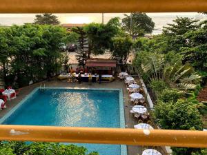 an overhead view of a swimming pool with tables and umbrellas at Hôtel Copacabana Kribi in Kribi