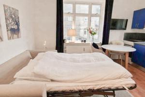 a living room with a large white bed in it at Central 1BR Studio - Walk Everywhere in Aarhus in Aarhus