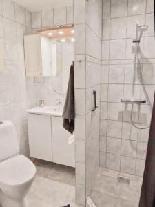 a white bathroom with a shower and a toilet at Central 1BR Studio - Walk Everywhere in Aarhus in Aarhus