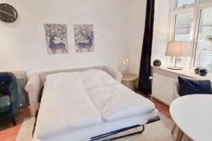 a white couch in a living room with a table at Central 1BR Studio - Walk Everywhere in Aarhus in Aarhus