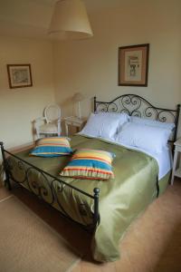 a bedroom with a large bed with two pillows at Casale DI Tormaggiore Villa And Country Suites in Pomezia