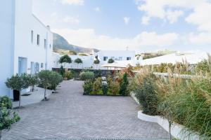 a courtyard with plants and white buildings at SN Santorini Apartments in Kamari