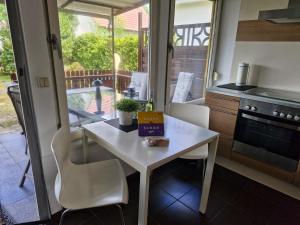 a small kitchen with a white table and chairs at Ferienhaus Marc in Göhren-Lebbin +13 photos
