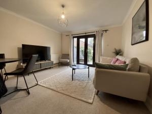 a living room with a couch and a table at Comfortable 2 Bedroom House in Bracknell in Bracknell