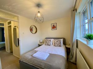 a bedroom with a bed and a window at Comfortable 2 Bedroom House in Bracknell in Bracknell