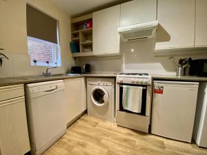 a kitchen with a washing machine and a dishwasher at Comfortable 2 Bedroom House in Bracknell in Bracknell