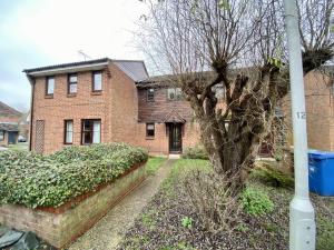 a brick house with a tree in the yard at Comfortable 2 Bedroom House in Bracknell in Bracknell