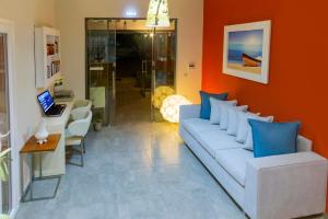 a living room with a white couch and blue pillows at Evripidis Hotel Afitos in Afitos