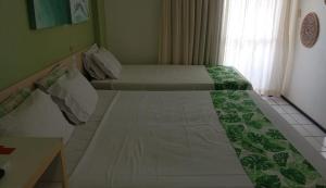 two beds in a small room with a table at Hotel em Barreirinhas in Barreirinhas +18 photos
