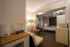 a kitchen with a refrigerator and a room with a bed at Apartmány Caffe & Grill in Roudnice nad Labem