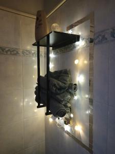 a bathroom with a shelf with towels and lights at Suite 71 in Fusignano