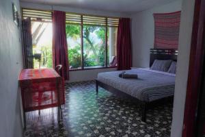 a bedroom with a bed and a large window at Leokap Homestay in Tuktuk Siadong