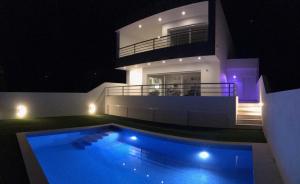 a large house with a swimming pool at night at DuMar Beachouse in Salema