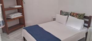 a bedroom with a bed with white sheets and pillows at Kasa Mare studios Maresias in São Sebastião